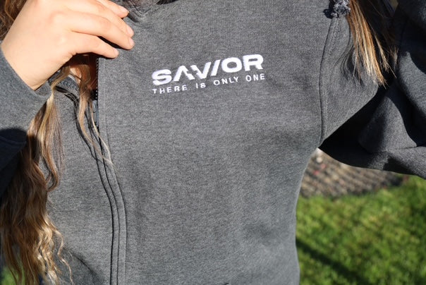 Gray hoodie with 'SAVIOR THERE IS ONLY ONE' text worn by a person outdoors.