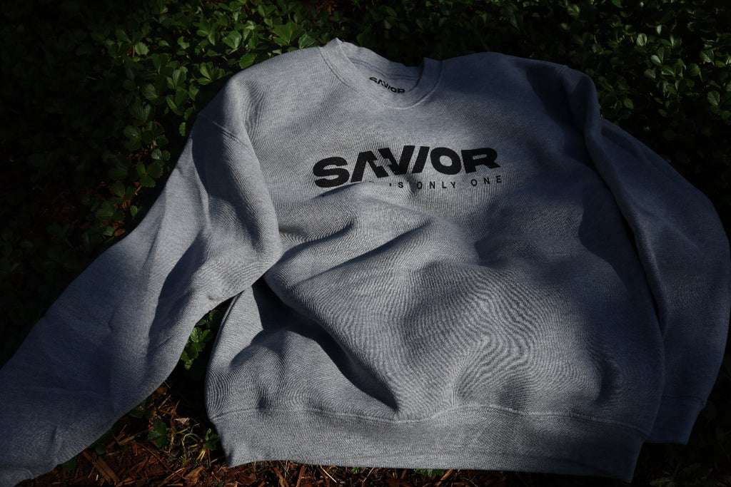 Gray sweatshirt with 'SAVIOR' text on grass